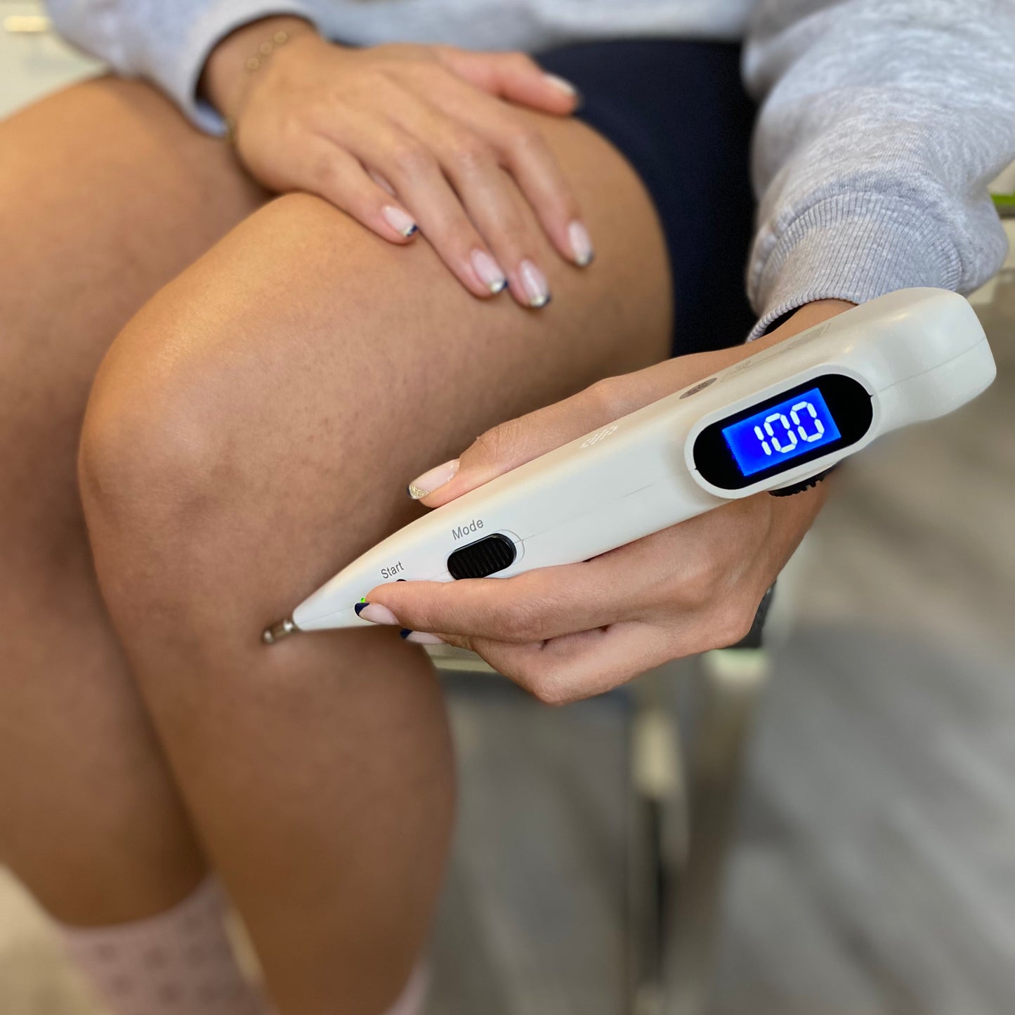 Person using MagicAcuPen acupressure pen on acupressure point ST36to relieve stiffness